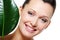 Green leaf near the happy laughing face of woman