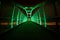 Green LEDs illuminate pedestrian walkway over highway at night