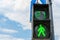 Green light on a pedestrian traffic light against a blue sky. Safe crossing of the road by pedestrians. Place for