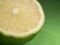 Green lime on a colored background. Close-up. Half a citrus fruit.