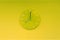 Green lime round modern analog glass clocks hang on a light yellow green wall. Shows the current time eight pm