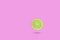 Green lime slic on vibrant pink color background. Minimal summer concept.