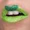 Green lips with sparkles covered with gemstones. Beautiful green lipstick on her lips, white teeth open mouth. Lip art