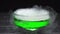 Green liquid boils giving off smoke in a glass bowl on a black background