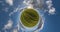 green little planet transformation with curvature of space among fields in evening day and beautiful clouds at sunset