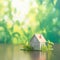 Green living concept Miniature house with a natural bokeh backdrop