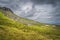 Green, long grass, large boulders and rubble on Cuilcagh Mountain mountainside