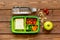 Green lunch box for kid on wooden background top view