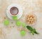 Green macaron with a cup of tea