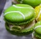 Green macarons hor` d`oeuvres filled with vanilla ice cream on crystal glass dish