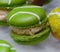 Green macarons hor` d`oeuvres filled with vanilla ice cream on crystal glass dish