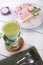 Green macha tea glass served with cheese cake served on wooden board