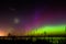 Green, magenta and purple aurora borealis with meteor