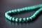 Green malachite necklace on a dark background