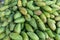 Green mangoes lying on a market counter. Exotic fruits of Asia