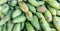 Green mangoes lying on a market counter. Exotic fruits of Asia