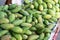 Green mangoes lying on a market counter. Exotic fruits of Asia