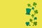 green manâ€™s hat or top hat, clover leaves or shamrocks on yellow background