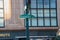 Green Market Street sign on a green pole with a large multi-pane window on an old office building in the background.