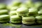 Green matcha tea macaroons close-up on a dark grey background with matcha powder. Matcha green tea macarons with pistachio cream,