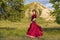 On green meadow against of mountain and summer sunset, young girl in ball gown is dancing incendiary dance.