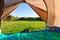 Green meadow and forest seen thru open tent door