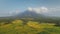 Green meadow at Mayon volcano eruption aerial. Nobody nature landscape of cloudy fog above mount