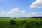 Green meadows gave forests far away. thin snake road. blue sky a