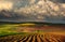 Green meadows landscape in countryside hills on impressive huge clouds in sky, beauty in nature