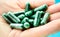 Green medical pills on hand