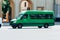 Green Mercedes-Benz Sprinter minibus van on the city road. Commercial auto in fast motion with blurred background