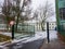 Green metal entrance gate to a school on a cold snowy winter day in Poznan