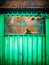 Green metal shack detail. Mesh on a window.