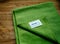 Green Microfibre cloth AMWAY HOME on wooden background