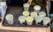 Green milke tea sample in mini white plastic tasting cup on black tray.