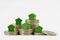 Green miniature houses on coin stacks on white background - Concept of real estate investment, mortgage, home insurance and loan,