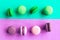 Green mint and pink macaroons on geometric green and purple background.