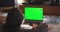 Green mockup screen, chroma key of laptop. Business woman working on computer with tracking markers. Typing girl