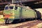 Green modern Russian locomotive with red stripes on cabin