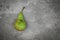 Green mottled pear on grey background