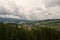 Green mountain farmland with stormy clouds