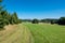 Green mountain landscape. Rural path under clear blue summer sky