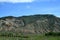 Green mountains and canyons of the state of Colorado. Below there is a railway with a long train