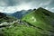 Green mountains and dark cloudy sky.