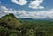 Green mountains and hills rise above the dense endless jungle