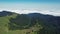 Green mountains landscape aerial. Over the hills and clouds.