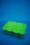 Green multifunctional sponge on a blue background