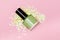 Green nail polish bottle on pink background. Green nail polish bottle decorated with small glitter green stars