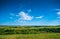 Green nature landscape with grassland hills and blue sky, tranquil countryside