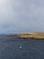 A Green Navigation Buoy with a solar Panel in the Shetland Sound on a Winters day in the Northern Approaches.